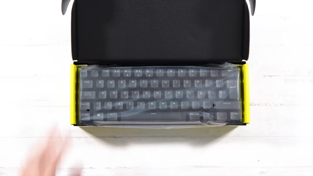 Se muestra la caja abierta del K70 Mini Pro Wireless. EN la caja se ve el teclado envuelto en un plástico protector.