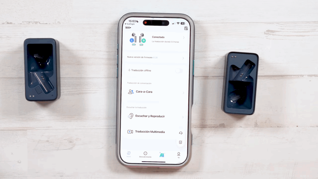 Aparece el estuche de los Timekettle  vacío, una parte en cada lado de la pantalla. El iPhone en el centro con la aplicación de los auriculares abierta.