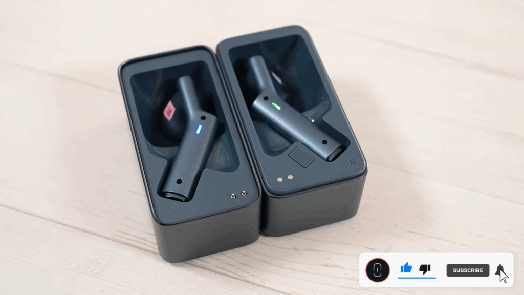 Aparece en estuche de carga de los auriculares Timekettle W4 abierto. En ellos se ven los dos auriculares con luz verde y azul 